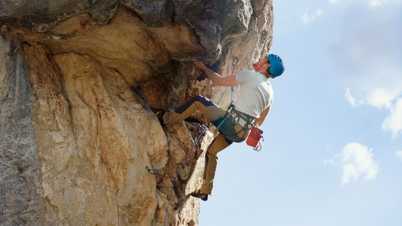 Man climbing a stone wall