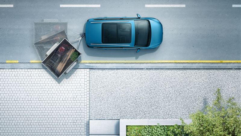 Sicht von oben auf VW Touran mit eingeschwenktem Anhänger zur Illustration des auf Wunsch erhältlichen Anhängerrangierassistenten „Trailer Assist“.