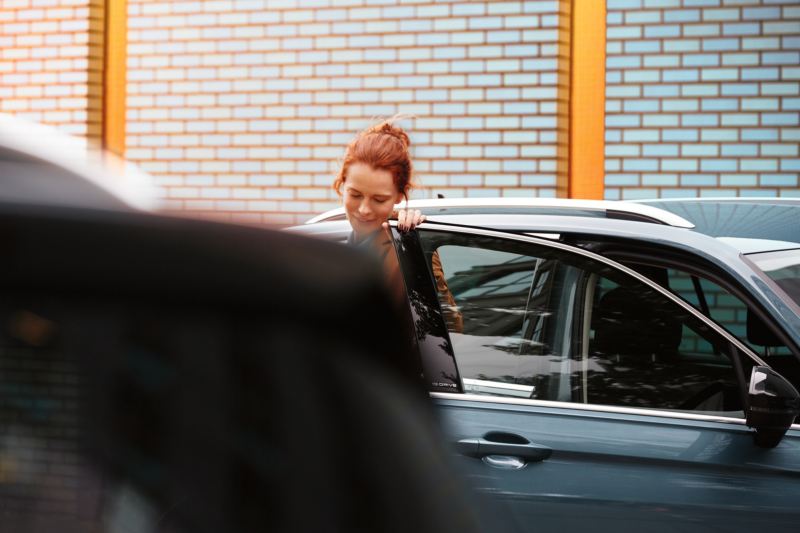 Kvinna vid öppen bildörr