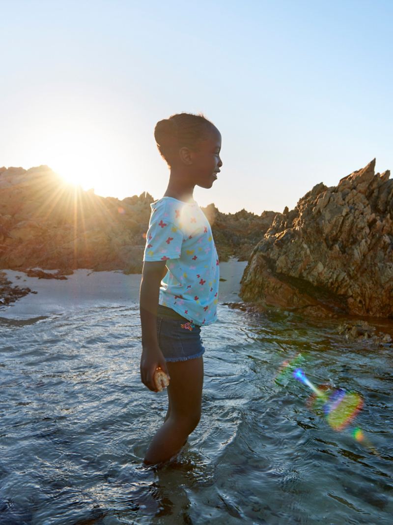 Daughter Charlotte splashing in the evening light in the sea