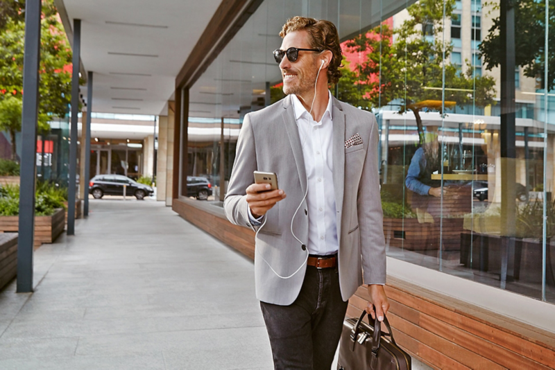 A business man walking down the street on his phone