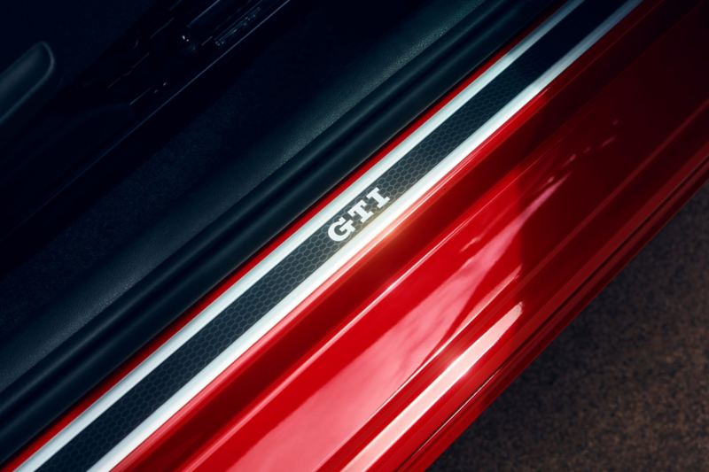 Detailansicht von VW up! GTI Einstiegsleiste in Tür mit Schriftzug „GTI“ in Chrom.