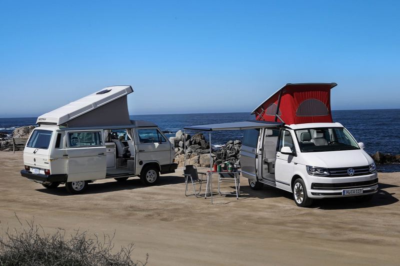 VW T3 and T6 California camper vans parked by ocean
