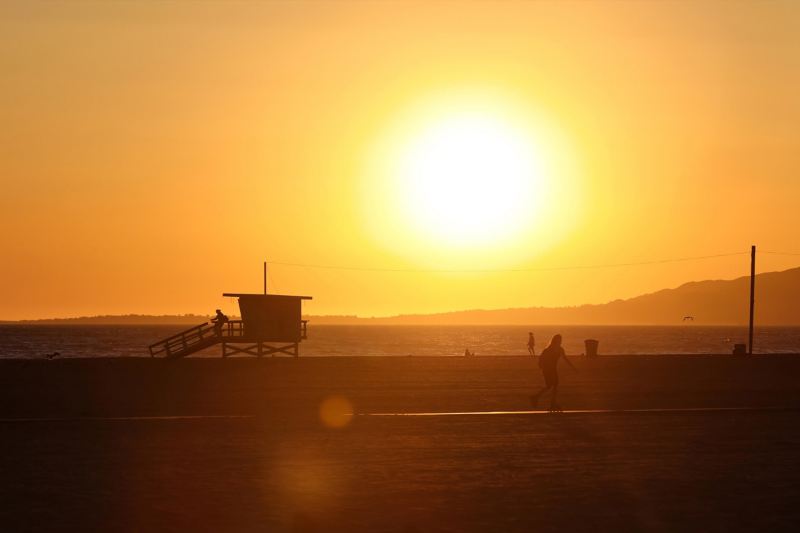 People playing on California beach at sunset