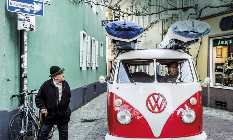 Red and white camper van on cobbled street