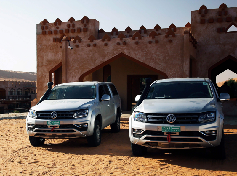 Two grey Amarok front view next to a middle-eastern style building