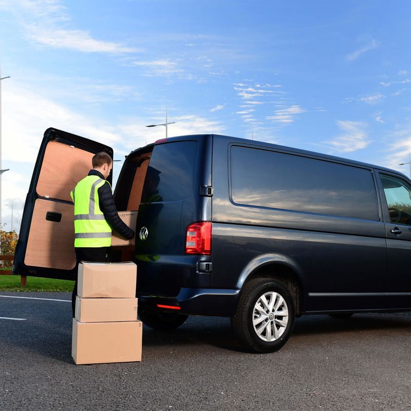 Van driver loading boxes into a van