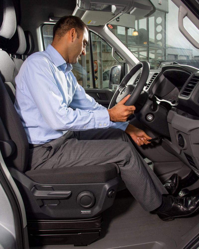 Man in van adjusting steering wheel