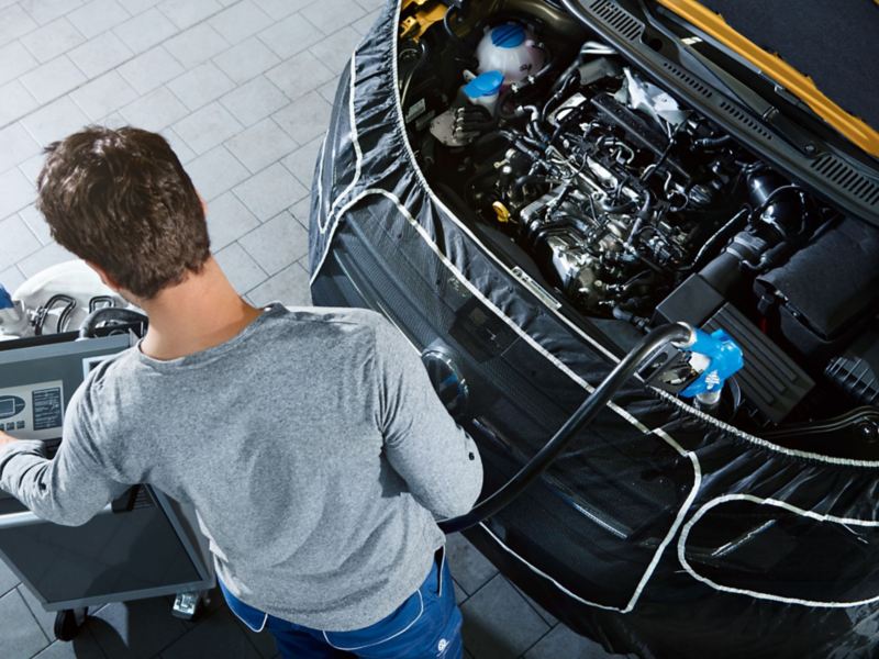 Mekaniker fyller på med AdBlue-vätska i en Volkswagen transportbil