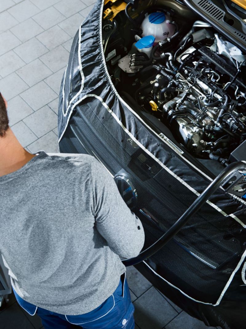 Mekaniker fyller på med AdBlue-vätska i en Volkswagen transportbil