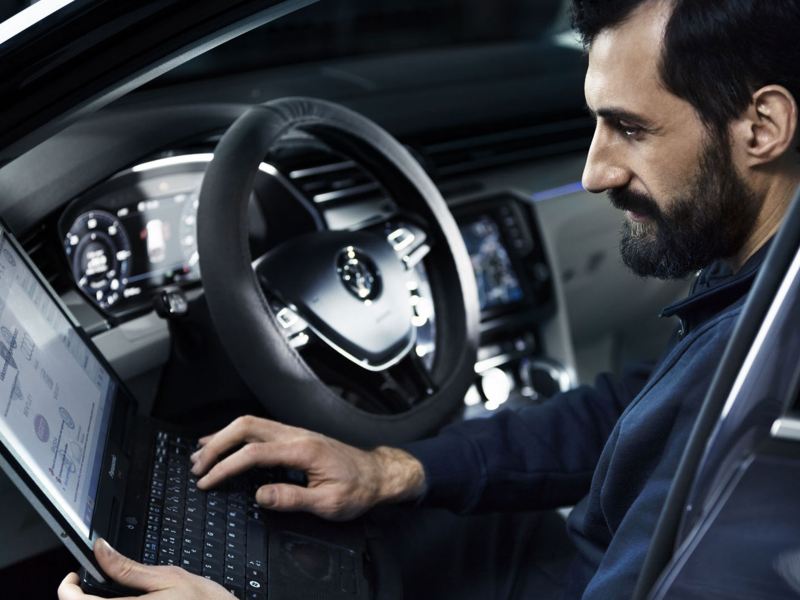 Mekaniker sitter i en VW Transportbil och utför service