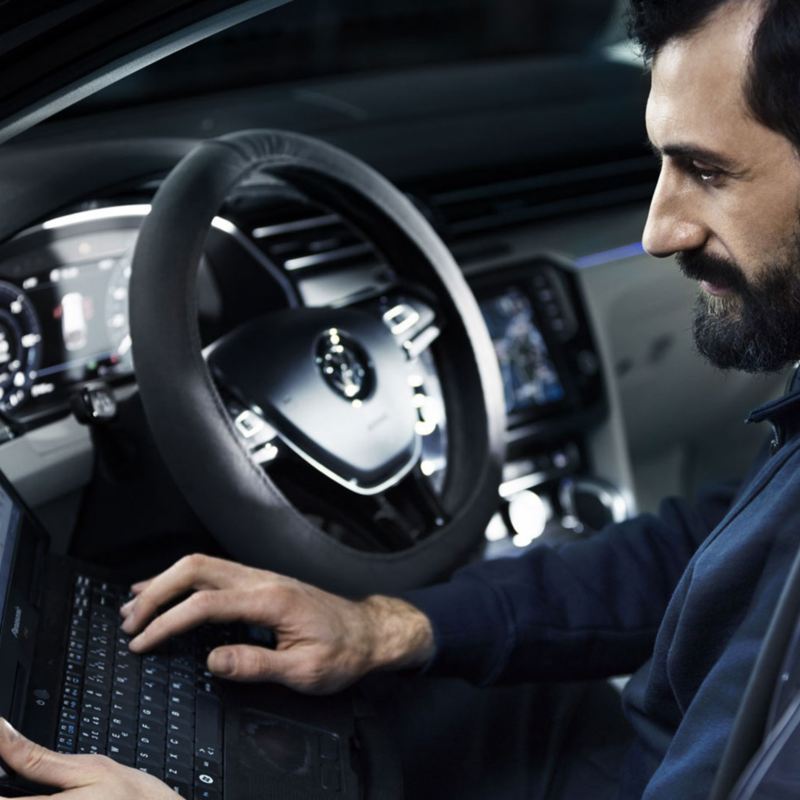 Mekaniker sitter i en VW Transportbil och utför service