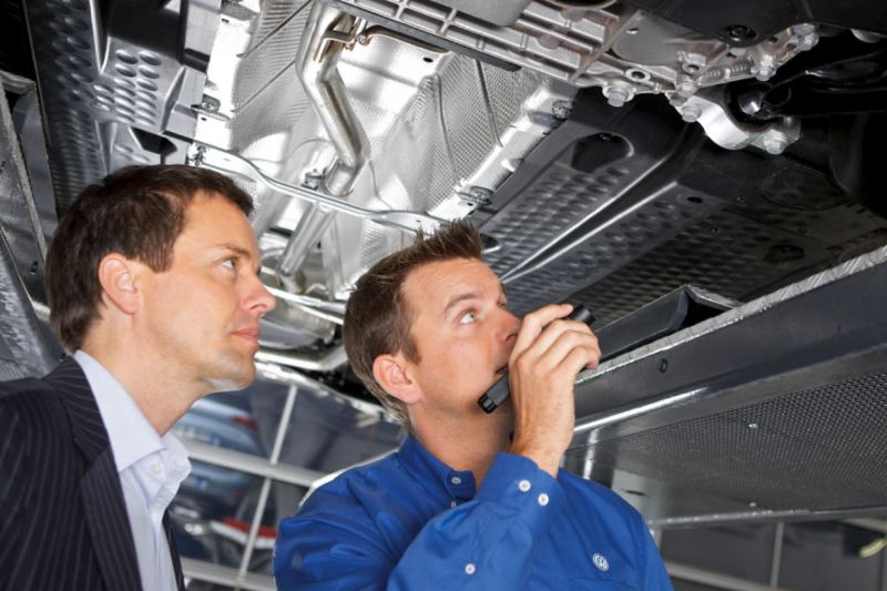 technician and manager inspecting VW van underside
