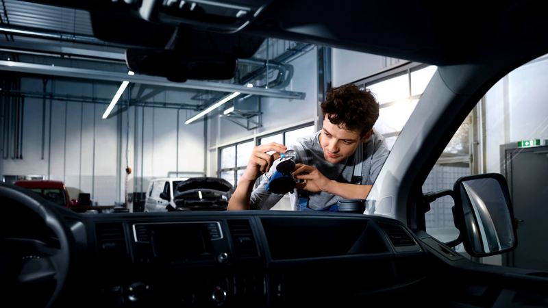 VW van technician replacing windscreen