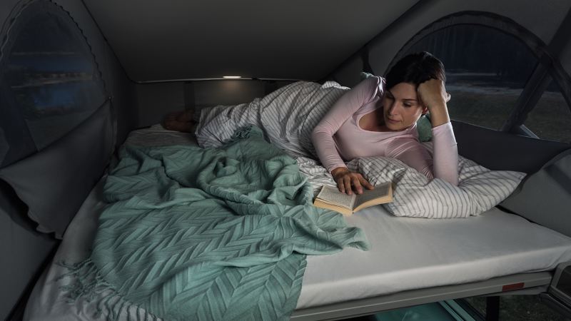 Kobieta czytająca książkę na łóżku w kamperze California 