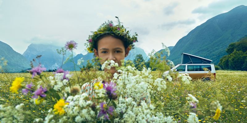 A girl with a flower wreath in a field of flowers.