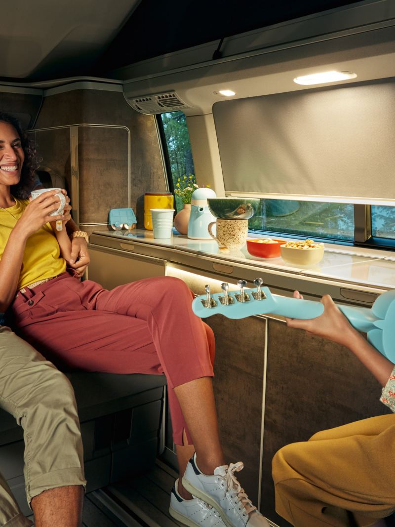 En familj roar sig med lite gitarrspel i en VW California 6.1 campingbuss