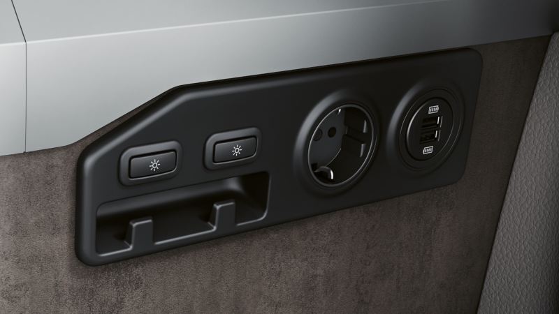 Eine 230-V- und zwei USB-Steckdosen an der Stirnseite des Küchenschranks eines VW California.