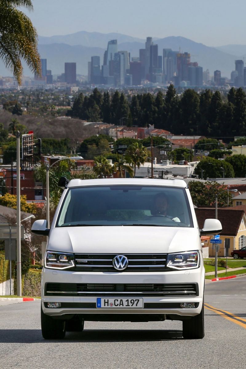 Ein Volkswagen Nutzfahrzeuge California fährt eine kalifornische Straße entlang.