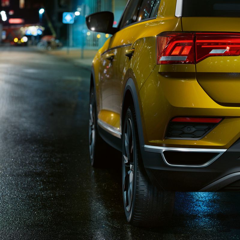 Rear shot of a yellow Volkswagen T-Roc, on a dark brick road