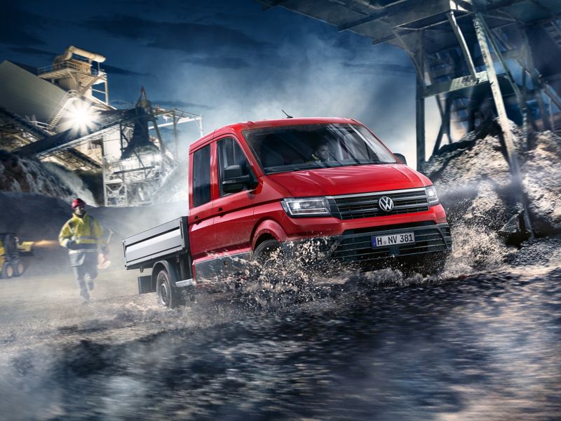 Nous sommes à l’aube, il fait encore sombre. Le Crafter à plateau roule sur un chantier fortement éclairé de façon dynamique.