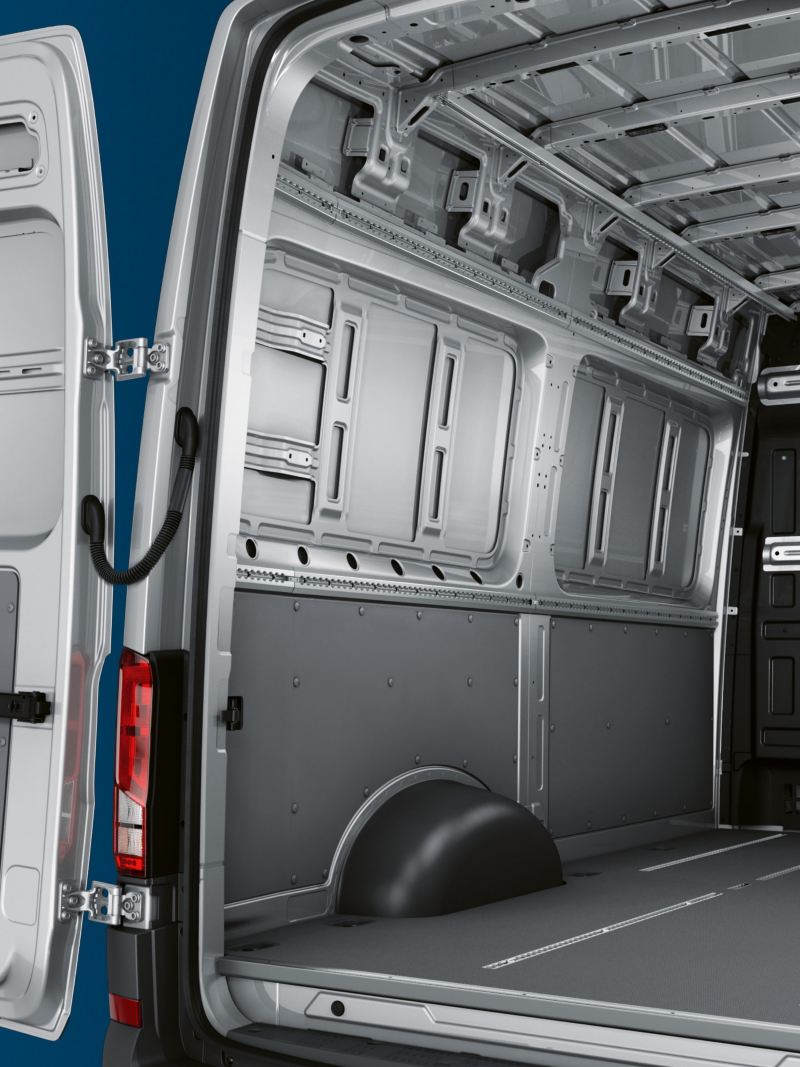 Vista posteriore in diagonale dell’e-Crafter. Attraverso le porte posteriori a battenti aperte si vede l’interno del vano di carico.
