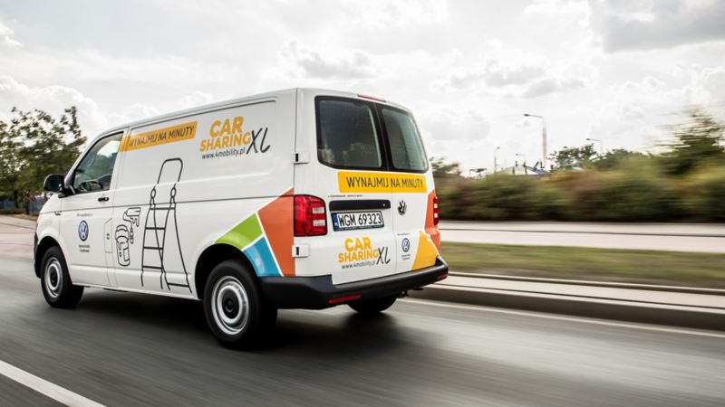 Transporter w okleinie o carsharingu jedzie po drodze
