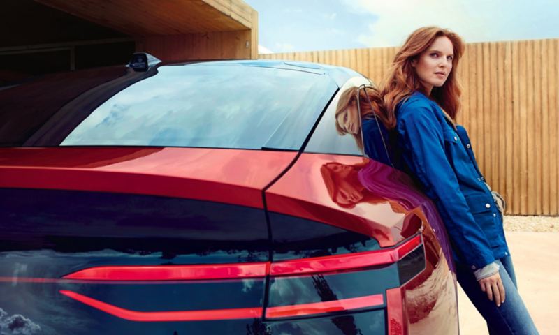 Una donna appoggiata a Volkswagen ID. Crozz vista posteriormente