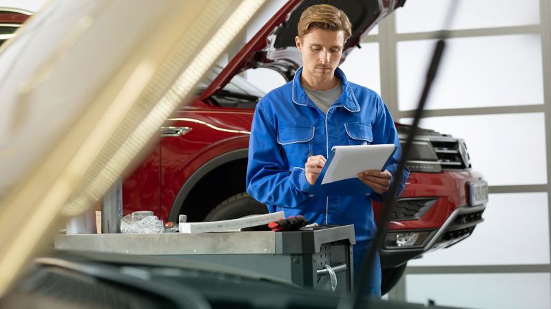 Un technicien Volkswagen vérifie les points de contrôle Express Service en atelier