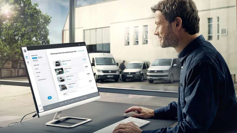 Un homme regarde un écran avec ses financements en Crédit-Pro Volkswagen Véhicules Utilitaires