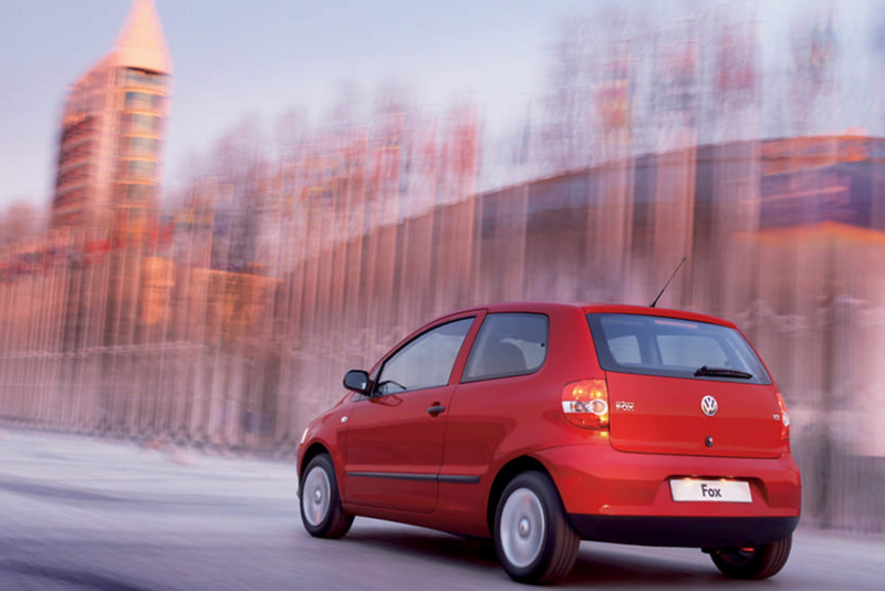 Rear view of a red Volkswagen Fox, in the snow.