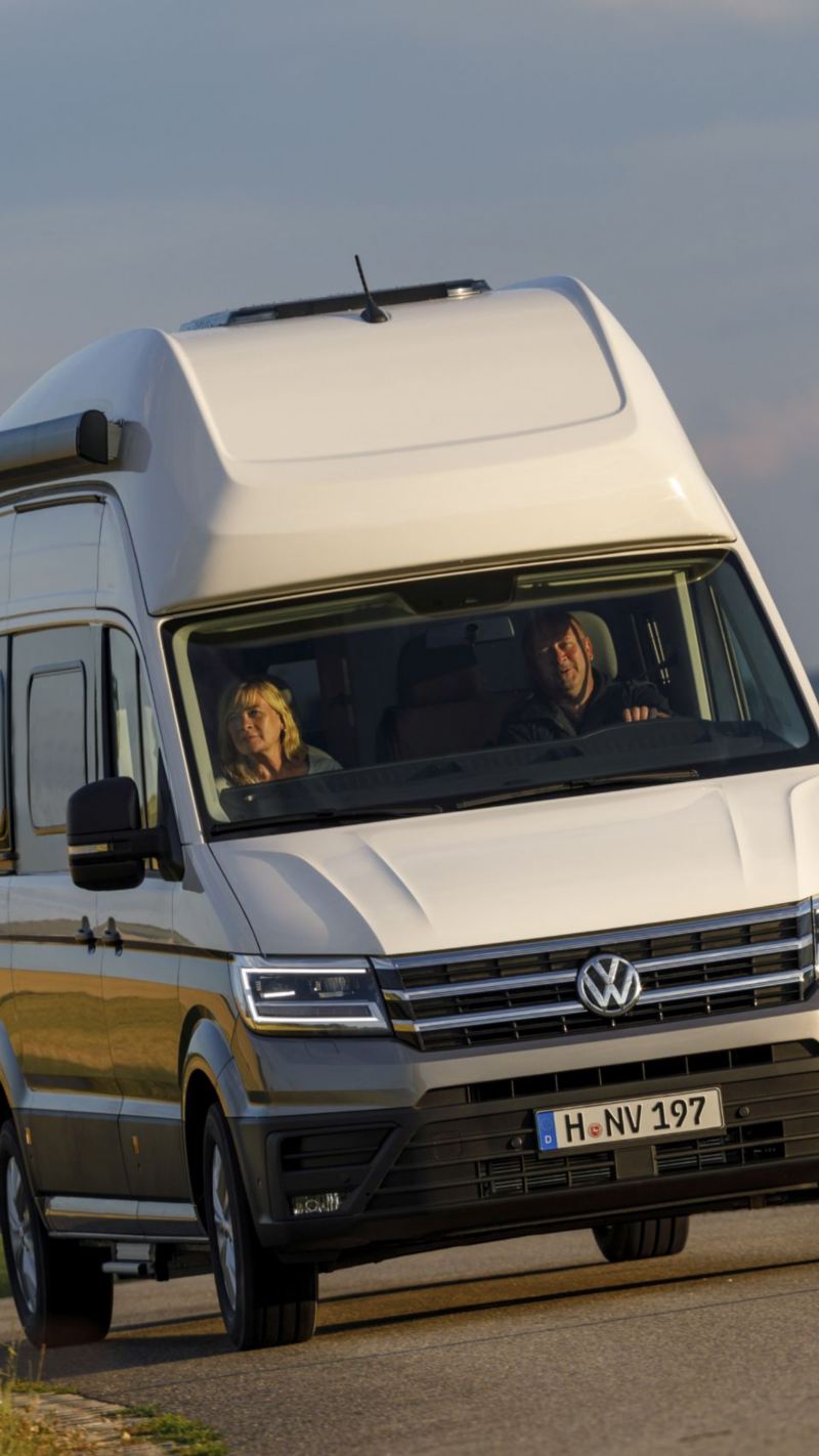 Volkswagen Grand California na drodze przy zachodzie słońca