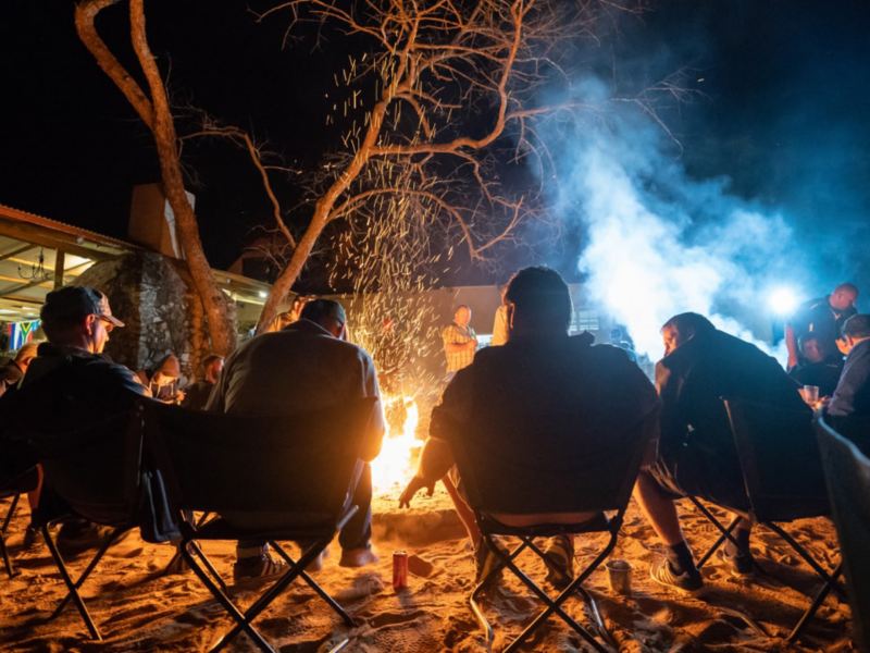 Nogle deltagere i Spirit of Amarok 2018 sidder sammen ved lejrbålet om aftenen.