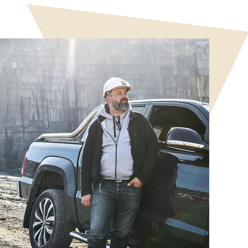 Frederic De Meyer poseert naast zijn geparkeerde Volkswagen Amarok in de steengroeve