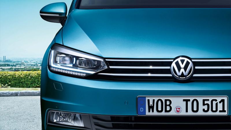 Dettaglio della luce diurna a LED anteriore destra accesa di Volkswagen Touran, ferma in un parcheggio.