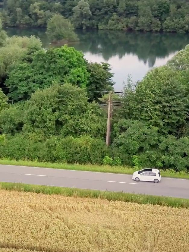 The e-up! drives on a road beside a river