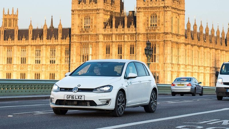 An e-Golf GTE driving across Westminster bridge in front of the Houses of Parliament
