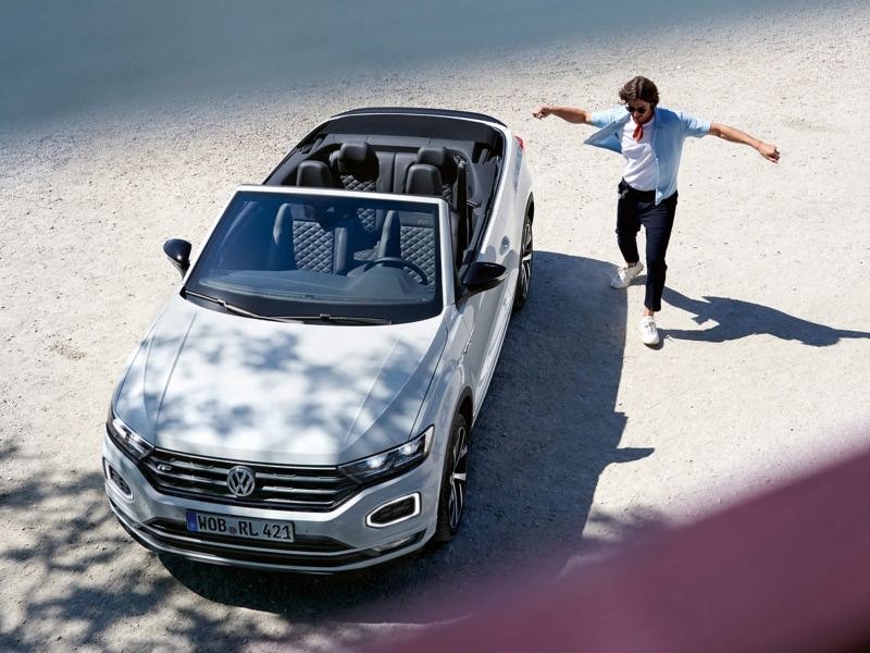 Man jumping next to a T-Roc Cabriolet car