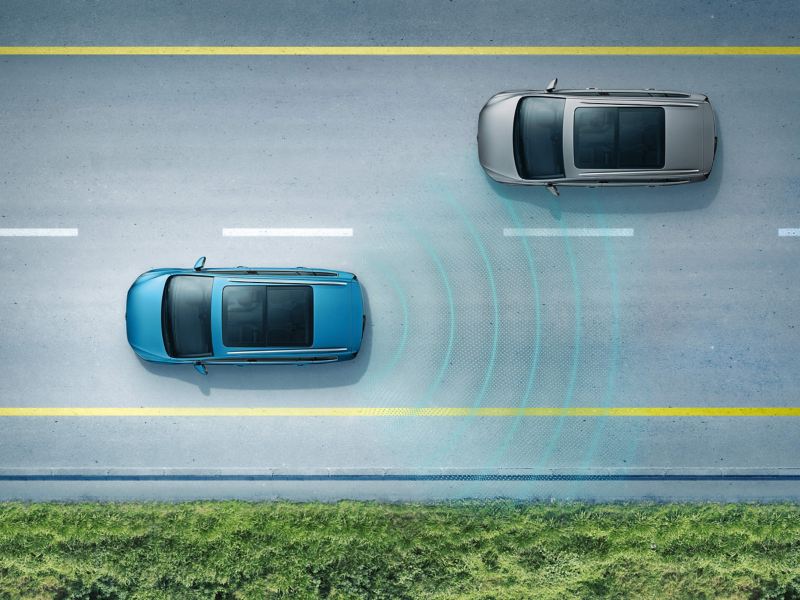 A blue Volkswagen Touran driving on the road with the Lane Assist in action