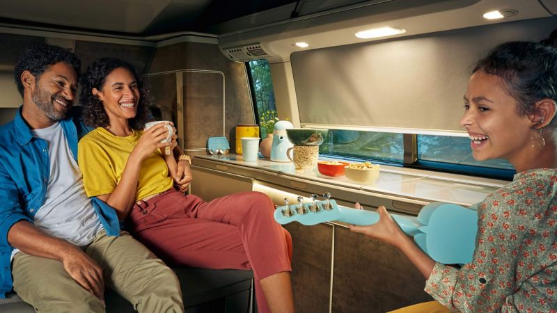Young girl playing with family in VW California kitchen
