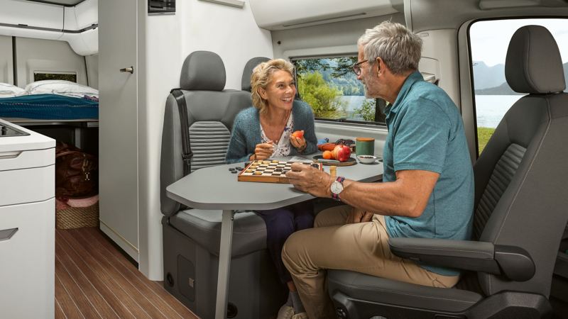 Couple playing board games in VW Grand California living area