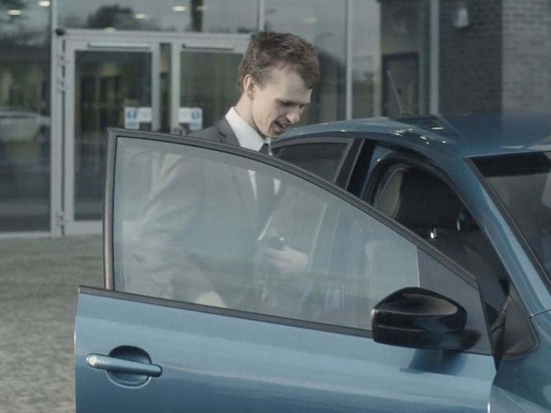 Man in suit opening a Volkswagen car door