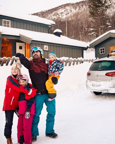 family infront of a house and the e-Golf with snowboard holder