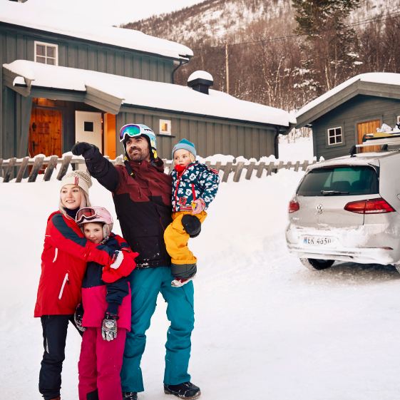 family infront of a house and the e-Golf with snowboard holder
