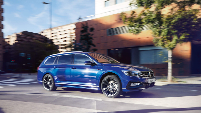 A blue VW Passat Estate being driven on a road