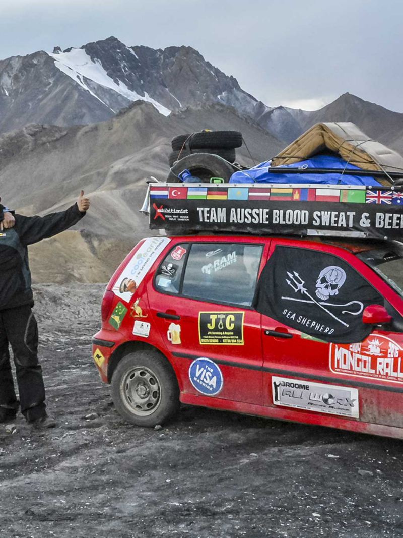 Deux hommes avec les pouces vers le haut à côté de leur Volkswagen Polo 3. pendant le Polo Rally Mongol