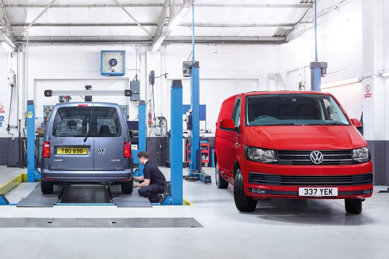 VW vans in garage being inspected by mechanic