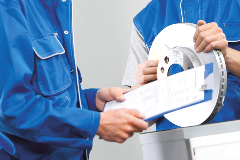 Technicians in VW Van Centre checking brake disc