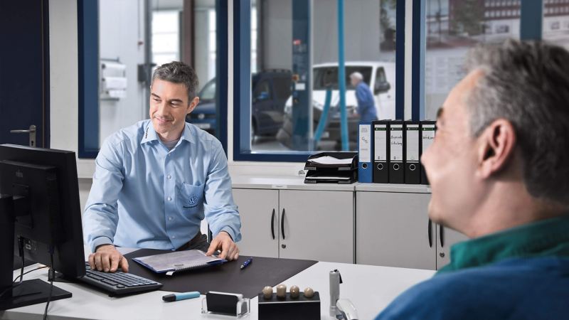 Customer and van dealer at desk in VW Van Centre