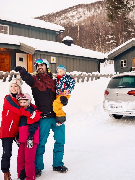 Thomas e la sua famiglia sulla neve vicino a e-Golf Volkswagen